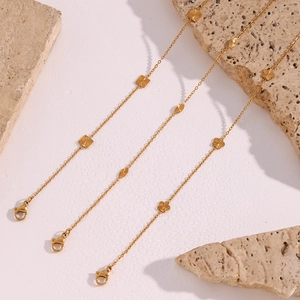 Detailed view of three 18K gold plated stainless steel bracelets with geometric charms
