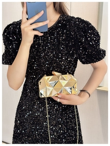 Detail of a geometric acrylic evening clutch with gold and silver metallic panels