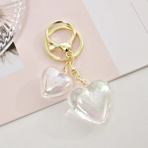 Close-up of double acrylic heart keychain with holographic finish and golden clasp