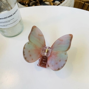 Detail showing marble texture butterfly claw clip with gold spring and pink green finish