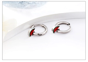 Detail of silver hoop earrings featuring cute red watermelon charms with enamel finish