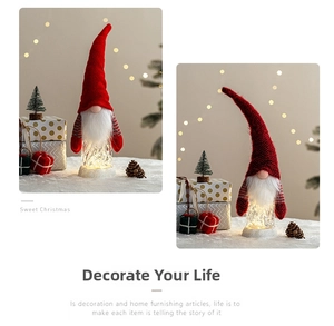 Nahaufnahme eines leuchtenden Weihnachtszwergs mit roter Strickmütze und LED-Glasfuß