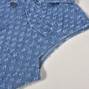 Close-up of distressed denim vest featuring frayed edges and vintage washed finish detail