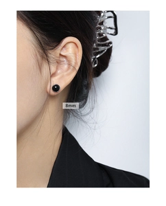 Detail view of 8mm round black agate S925 sterling silver stud earring on ear