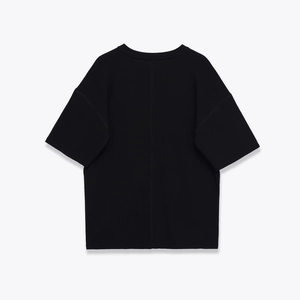 Détail du dos d'un t-shirt noir oversize avec une couture verticale centrale distinctive