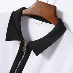 Detailaufnahme des weißen Polo-Ausschnitts mit Reißverschluss, schwarzem Kragen und Stoff