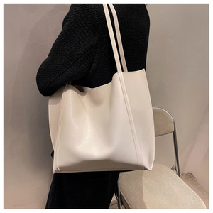 Macro detail of creamy white oversized leather tote bag showing high-quality stitching