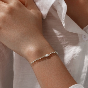 Detailed view of a silver eye-shaped tennis bracelet with sparkling white zircon crystals