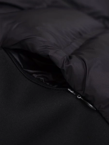 Détail de fermeture éclair et texture de tissu matelassé noir sur gilet à capuche