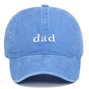 Detail of white embroidered dad text on washed blue cotton baseball cap surface