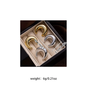 Detailed view of silver and gold C-shaped hoop earrings inside a premium jewelry box
