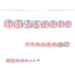 Détail de faux ongles de pieds avec papillons 3D bleus et ornements en strass