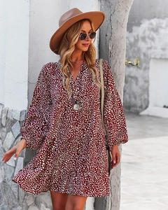 Detail of burgundy V-neck leopard dress featuring long sleeves and ruffled hem layers