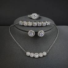 Detail of luxury silver jewelry set featuring square zircon stones on grey velvet display
