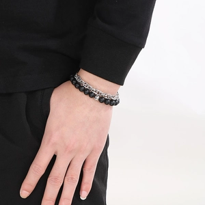 Close-up of men's layered bracelet with matte black onyx beads and silver steel chain