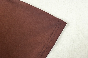 Detailed close-up of double-needle stitching on the hem of a brown bodycon dress