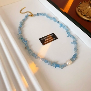 Detail of blue crystal stone necklace with a pearl and S925 silver clasp in a tray