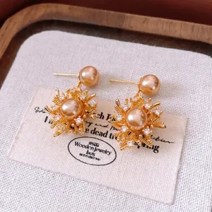 18K gold plated pearl firework earrings with micro-set zircons on wooden tray