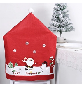 Détail d'une housse de chaise Père Noël rouge avec pompon pour déco de table Noël