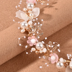 Detail of bridal headband featuring gold leaves, pearls and pink floral accents