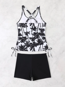 Detailed flat lay of a two-piece tankini swimsuit featuring palm tree prints and boy shorts