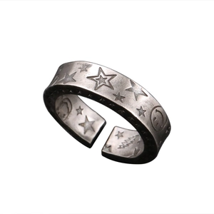 Detailed close-up of vintage silver ring featuring engraved star and smiley face motifs