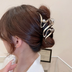 Irregular silver metal hair claw with pearl accent on model for minimalist style