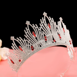 Macro shot of silver wedding crown with red marquise gems and white sparkling rhinestones