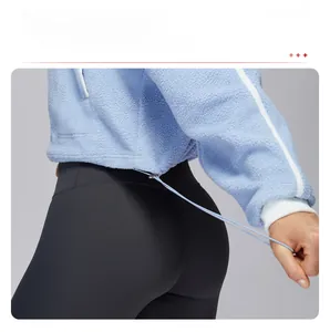 Detail of adjustable drawstring hem with metal buckle on blue fleece sports jacket