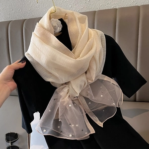 Detail of champagne sheer scarf with shimmering metallic finish and white pearl beads