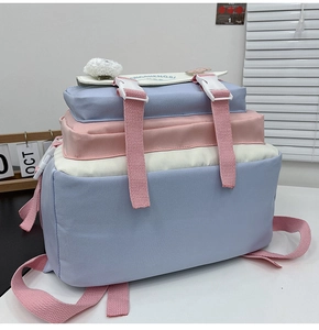 Detail of multi-compartment blue and pink school backpack with buckles and plush accessory
