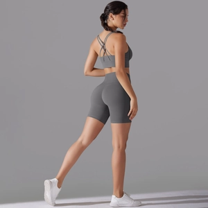Dettaglio del reggiseno sportivo con incrocio e pantaloncini da palestra a vita alta grigi
