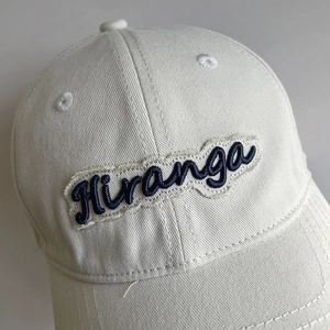 Minimalist beige cotton baseball cap with blue Hiranga letter embroidery on the front