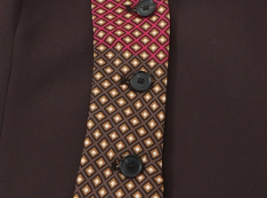 Detailed close-up of dark brown fabric top with geometric pattern and black buttons