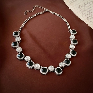 Detail of vintage silver necklace featuring black square gems and sparkling rhinestones
