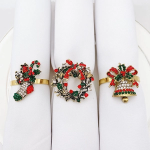 Close-up of Christmas napkin rings set featuring gold stocking, wreath, and bell designs