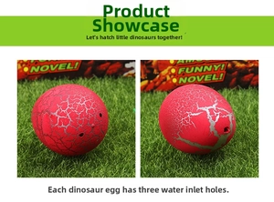 Detail of red hatching dinosaur egg toy with grey cracks and three water inlet holes