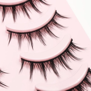 Five pairs of spiky natural black false eyelashes set on a professional pink tray