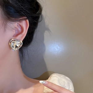 Macro shot of silver heart-shaped clip earrings with sparkling oversized crystals