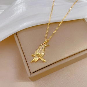 Elegant gold titanium necklace with a bird pendant paved in crystals on silk