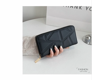Detail of black quilted PU leather wallet for women with golden metal zipper closure