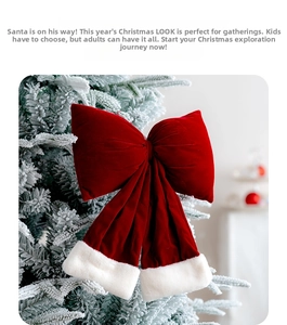 Detail of red velvet Christmas bow with faux fur trim hanging on a snowy tree branch
