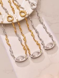 Detail of eye-shaped pendants with marquise zircon and freshwater pearls on steel chains