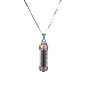 Detailed macro of a rainbow stainless steel cylinder perfume bottle pendant with black gravel