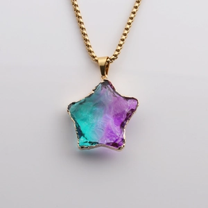 Macro view of purple and green gradient glass star pendant with gold plated metal edge