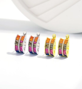 Macro detail of S925 silver hoop earrings with two rows of colorful triangle gemstones