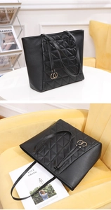 Close-up of black quilted tote bag with matte PU leather and gold ring strap detail
