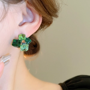 Primo piano di modella che indossa orecchini a cubetto di cristallo sfaccettato verde