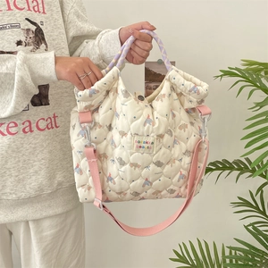 Détail du sac fourre-tout matelassé avec imprimé cartoon et anses tissées à la main