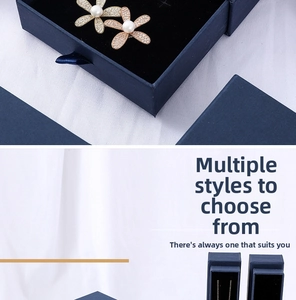 Detail of flower-shaped pearl and zircon jewelry set in premium blue slide gift boxes